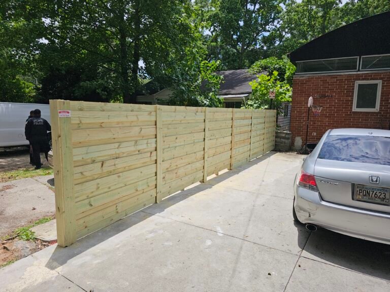 Completed wood privacy fence with a capped top rail